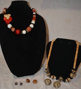 lot 212 image: Wood jewelry selection. Includes 2 necklaces including one with a carved figural leaf station and 3 pairs of earrings.