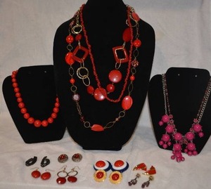 lot 215 image: Red jewelry selection. Includes 6 necklaces and 8 sets of earrings. Varying styles and materials.
