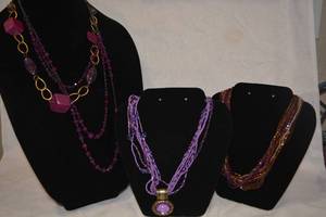 lot 213 image: Purple necklace selection including a multi strand micro bead torsade, faceted raspberry glass and more. 4 necklaces. Varying styles and materials.