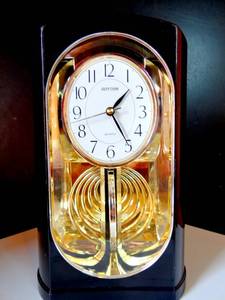 lot 66 image: MESMORIZING RYTHUM PENDULUM CLOCK - TAKES C BATTERY (PLASTIC CASE)