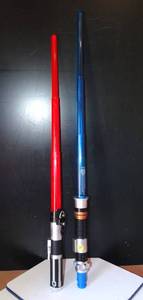 lot 179 image: PAIR OF STAR WARS STYLE RETRACTABLE LIGHT SABERS AS SHOWN - BOTH POWER ON (RED & BLUE)