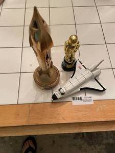 lot 90 image: MC Souvenir Space Bank, Plastic Astronaut Figure, and Metal Shuttle Model&nbsp