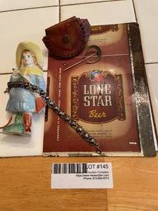 lot 145 image: Vintage mementos of West - Lone Star beer can tin sheet, porcelain figure of Annie Oakley, leather coin wristlet, silver puffed heart bracelet and Horseshoe stick pin.