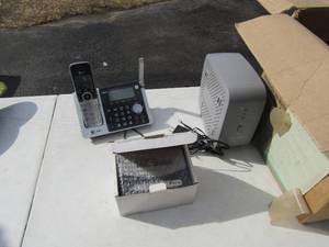 lot 88 image: Emerson switchboard NIB, used  cordless ATT phone used, Belkin battery back up unit and a box of phone and computer cords