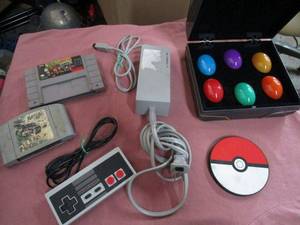 lot 55 image: VINTAGE NINTENDO LOT- WIRED NINTENDO CONTROLLER, SUPER NINTENDO DONKEY KONG COUNTRY 2 GAME, NINTENDO 64 NASCAR GAME, WII POWER CORD, POKEMON USB CHARGER, MARVEL CAPCOM GAME.