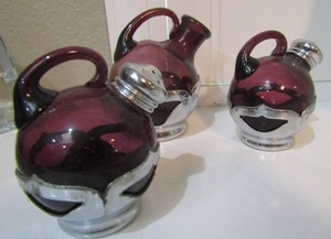 lot 71 image: VINTAGE FARBER BROTHERS SALT AND PEPPER SHAKERS,  OILOR VINGER  NO LID     PUPRLE GLASS ON A SILVER BASE 3 12IN HEIGHT