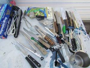 lot 63 image: Kitchen lot- opened packages of aluminum and  plastic wrap, knives, measuring spoons