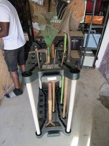 lot 90 image: Green lawn and garden tool holder with rakes, hoe and shovel