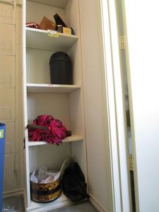 lot 218 image: CLOSET SHELF CONTENTS... VINTAGE GLASS CAKE TOPPER, COSTUME JEWELRY, FEATHERED HANDBAG, SMALL TRASH CAN, MINI CHRISTMAS TREE, FUEGO CUBANO CIGAR BOX AND MORE.