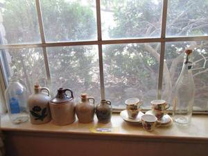 lot 225 image: DINING ROOM WINDOW LEDGE CONTENTS... VINTAGE CERAMIC JUGS WITH CORKS, CHINA TEA SET, MISC VINTAGE GLASS BOTTLES