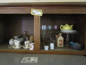 lot 226 image: KITCHEN CABINET CONTENTS... CAKE STAND, YELLOW TEA POT, IRIDESCENT WINE GLASSES, POACHED EGG HOLDERS, CORN STYLE BUTTER DISH AND MORE