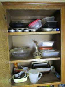 lot 257 image: CONTENTS OF KITCHEN CABINET, MUFFIN PANS, BREAD PANS, PLASTIC CONTAINERS, GLASS SERVING DISH, METAL PANS,&nbsp AND MORE.