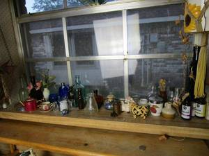 lot 263 image: KITCHEN WINDOW LEDGE KNICK KNACKS..VINTAGE SMALL BOTTLES, SMALL TEA CUPS, COW TRINKET BOX, WHOLE FOODS OILS, AND MORE.