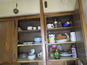 lot 294 image: CONTENTS OF 2 KITCHEN CABINETS.. VINTAGE WOODEN CORN ON THE COB HOLDERS, CHEESE GRATER, MUGS, GLASS PIE DISHES, GREEN GLASS JAR, MINI ESPRESSO CUPS, BUE PATTERN CHINA, AND MORE.