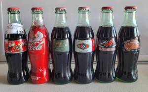 lot 135 image: LOT OF 6 COMMEMORATIVE COCA-COLA BOTTLES AS SHOWN.