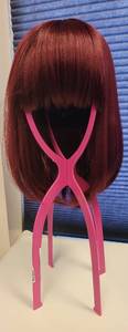 lot 526 image: WIG IN STYLE AND COLOR SHOWN WITH COLLAPSIBLE WIG HOLDER.