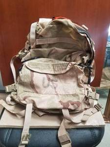 lot 64 image: US military camo backpack - seen action in Afghanistan