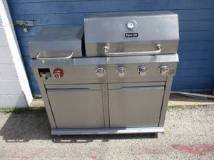 lot 31 image: Dyna-Glo Model DGX440SGP, 4-Burner Propane Grill in Stainless Steel with Griddle On Casters