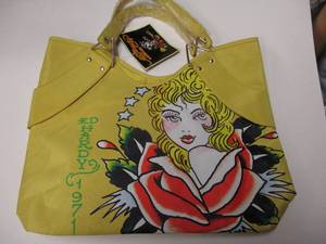 lot 149 image: 1971-ED HARDY-VERONICA YELLOW TOTE BAG BY CHRISTIAN AUDIGIER, STIL HAS TAG AND PLASTIC WRAPED HANDLES.