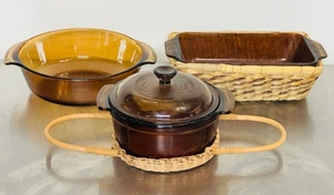 lot 59 image: Anchor Hocking Fire-King #437 Amber 1.5Qt Baking Bowl, 7.5 Bowl wLid and Wicker Carrier and #441 1Qt Baking Dish wWicker Carrier