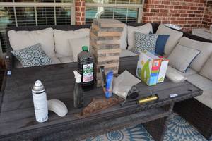 lot 205 image: Contents on Patio Table Tiki Oil, Cast Iron Towel Hanger, 2 Lounge Sit-n-Floats, Pool Volleyball Net, Outside Jenga Game, Inflatable Pump, and More