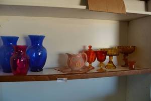 lot 224 image: Colored Glassware Amber Compotes, Sunrise Goblet with Eagle, Pink Depression Plate, and Blue and Pink Colored Vases