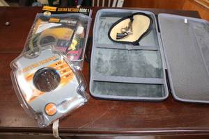 lot 182 image: Zippered Black Case, Tiny  Gun, Guitar Books, DVD and Strings and 10 Instrument Cable