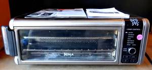 lot 287 image: Ninja SP101 Digital Air Fry Countertop Oven with 8-in-1 Functionality, Flip Up & Away Capability for Storage Space, with Air Fry Basket, Wire Rack & Crumb Tray, Silver $$$