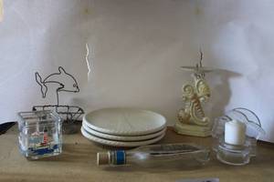 lot 85 image: American Atelier White Lighthouse Plates, Cast Iron Seashell Candle Holder, Avon Aftershave Ship Bottle, and Votive Holders