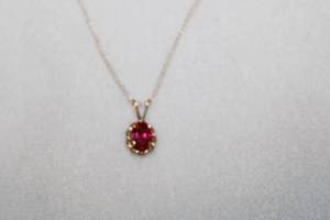 lot 108 image: 14K yellow gold and faceted Ruby pendant on 18L 14k gold chain. Ruby tested (approx. .50 carat oval). Matches Ruby earrings in Lot #120