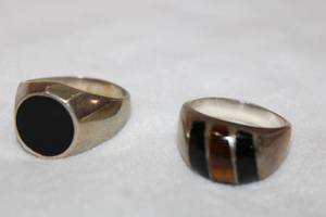 lot 129 image: (2) Taxco Sterling silver gemstone rings. Size 12 and 14. Tiger Eye and Black Onyx inset ring (Marked Mexico 925 with artisan Taxco initial, size 12) and inset Black Onyx (Marked Mex 925 and artisan Taxco initial, size 14)