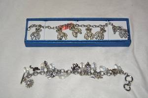 lot 604 image: (2) Polished Stainless Steel charm bracelets. Teddy bear charms are articulated and is 11L, fairy charm bracelet is about 8.5L