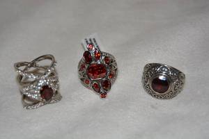 lot 628 image: (3) Sterling Silver Garnet rings. Two marked 925. Garnets tested, One has orange Spessartine Garnets. All 3 size 9.