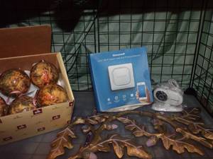 lot 70 image: Home Decor Balls, Honeywell Water leak and Freeze Detector, wifi camera, and heavy metal wall decor