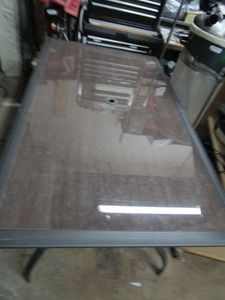 lot 260 image: OUTDOOR GLASS TOP TABLE W WOOD APPEARANCE