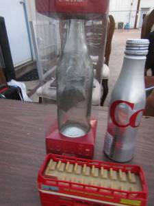 lot 11 image: 1900s Coca-Cola glass bottle, aluminum diet coke bottle, Scottish sight seeing tourist bus