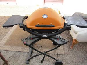 lot 30 image: WEBER GRILL ON WHEELS  COLLASPES FOR STORAGE  ORANGE