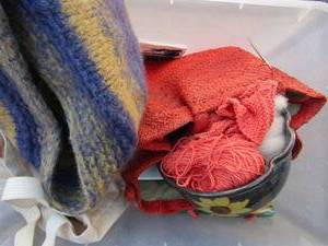 lot 296 image: clear tub of crocket itemsand cloth, 2 bags hand crocketed 1 is orange, 1 is purple and yellow