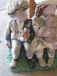 lot 102 image: solid concrete boy and girl yard art, holding a teddy  bear sitting on a bench,  18168