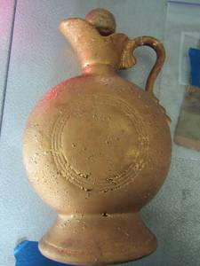 lot 146 image: 1956 JIM BEAM BOTTLE GOLDEN  with cork lid comes with article al paper work  very vintage. 106