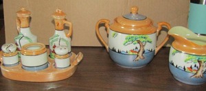 lot 174 image: LUSTERWARE Hand painted sugarcreamer oilvinegar salt&pepper shakers, spoon holder sitting inside the holder, l  ight house and tree design