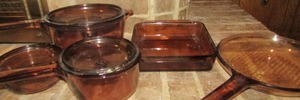 lot 195 image: Brown clear glass cookware, sauce pans with lids, skillet with lid and a casserole dish