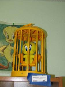 lot 247 image: 12 yellow bird cage with tweety bird, needs batteries for birdie to be able to swing and sing,