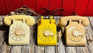 lot 32 image: Three Vintage Western ElecticBell Systems Rotary Desk Phones- Cream, Yellow, &amp Beige