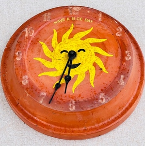 lot 176 image: Terra Cotta Sun Have a Nice Day Clock