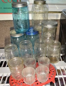 lot 302 image: Blue Colored and Clear Canning Jars, Votive Holders and Red Iron Trivet