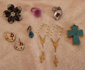 lot 264 image: Jewelry Jewelry selection. Includes a faux turquoise cross pendant with 22K artisan applied gold accents, Hello Kitty jewelry, (2) baby rosary bracelets, rings