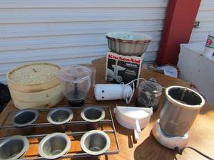 lot 101 image: Kitchen lot includes, Rival chopper, kitchen aid food grinder, Nutra bullet, wooden tortilla warmer, and more