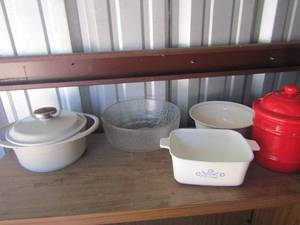 lot 115 image: clear glass salad bowl, corning ware bread pan, covered red canister, and a covered cast-iron dish