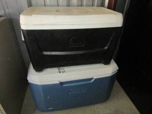 lot 122 image: black igloo cooler with 2 handles, blue Coleman cooler with 4 cup holders on the lid